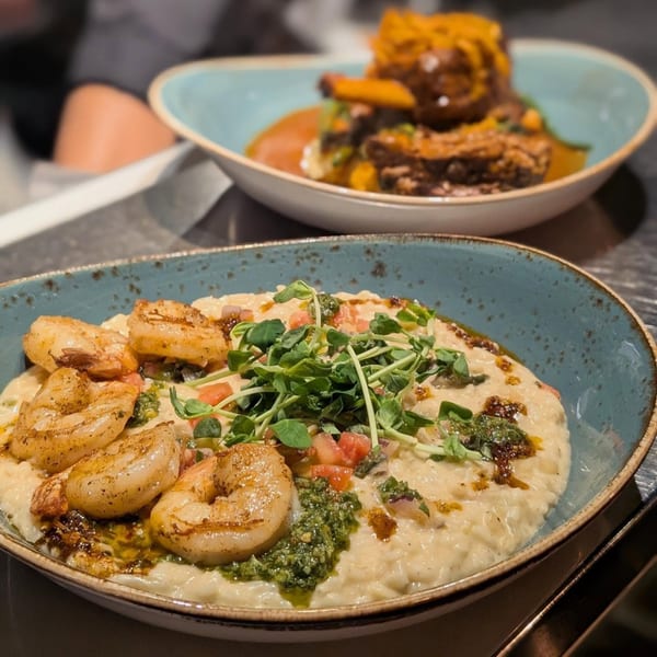 Two Italian dishes: shrimp risotto with pesto and microgreens, and braised short ribs in the background.